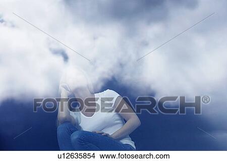 Young woman using mobile phone with reflections of clouds. View Large Photo Image Picture - Young woman using mobile phone with reflections of clouds.. Fotosearch