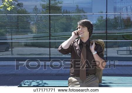 Businessman leaned on table in front of office on the mobile smiling. View Large Photo Image Stock Image - Businessman leaned on table in front of office on the mobile smiling.. Fotosearch