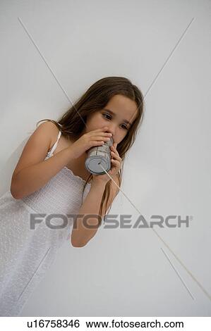 Stock Photograph - Girl using a tin can as a phone.. Fotosearch