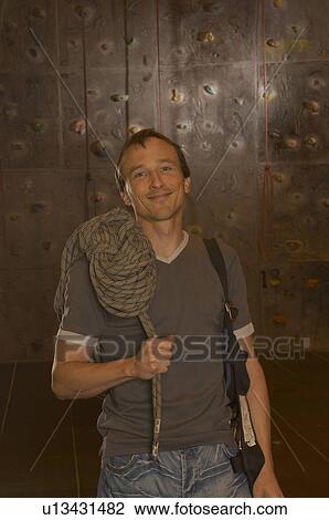 Man holding rope standing in climbing centre, smiling, portrait View Large Photo Image Stock Image - Man holding rope standing in climbing centre, smiling, portrait. Fotosearch