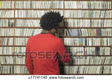Man looking at compact discs on shelves in music shop, rear view View Large Photo Image Stock Image - Man looking at compact discs on shelves in music shop, rear view. Fotosearch