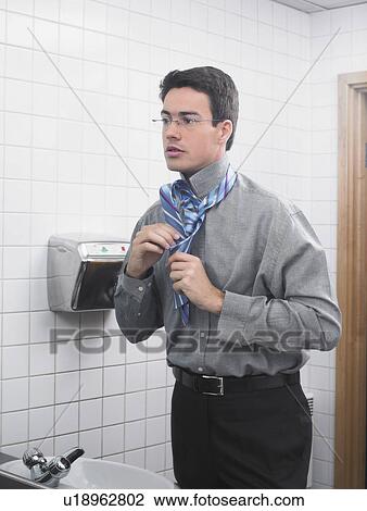 Man reflected in office washroom mirror doing up his tie View Large Photo Image Stock Image - Man reflected in office washroom mirror doing up his tie. Fotosearch