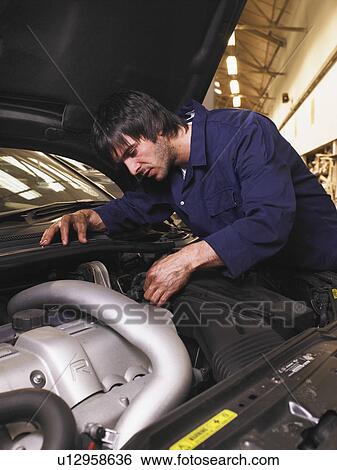 Mechanic working on an engine View Large Photo Image Stock Photograph - Mechanic working on an engine. Fotosearch