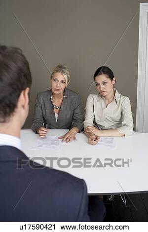2 businesswomen interviewing man View Large Photo Image Stock Image - 2 businesswomen interviewing man. Fotosearch