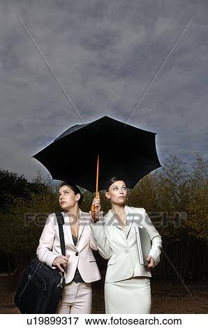 Stock Photo - 2 women under an umbrella. Fotosearch