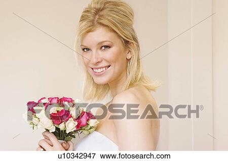 A bride smiling holding a bouquet View Large Photo Image Stock Photo - A bride smiling holding a bouquet. Fotosearch