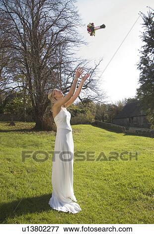 A bride throwing her bouquet of roses View Large Photo Image Stock Photo - A bride throwing her bouquet of roses. Fotosearch