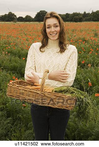 A female holding a basket of vegetables View Large Photo Image Stock Image - A female holding a basket of vegetables. Fotosearch