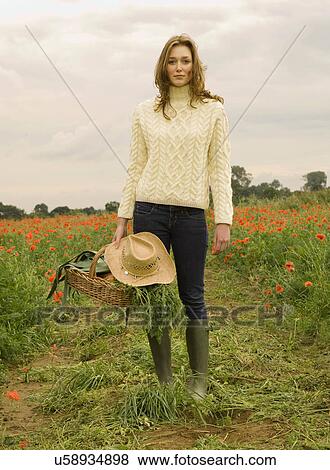Stock Photo - A female holding a basket of vegetables. Fotosearch