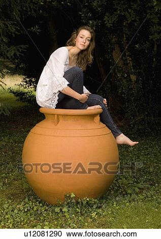A female sitting on a huge ceramic pot View Large Photo Image Stock Image - A female sitting on a huge ceramic pot. Fotosearch