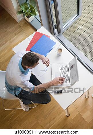 Stock Image - A man at his desk with laptop. Fotosearch