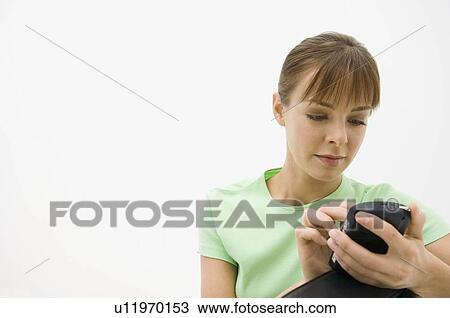 Stock Image - A woman using a blackberry. Fotosearch