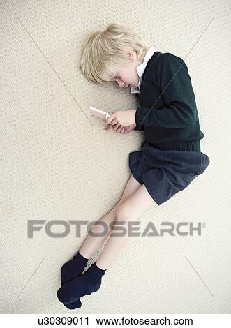 Boy lying on floor playing with nintendo View Large Photo Image Stock Image - Boy lying on floor playing with nintendo. Fotosearch