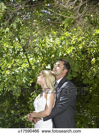 Stock Photograph - Bride and groom relaxing in woods. Fotosearch