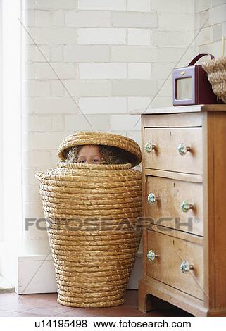 Stock Photo - Child hiding in laundry basket. Fotosearch