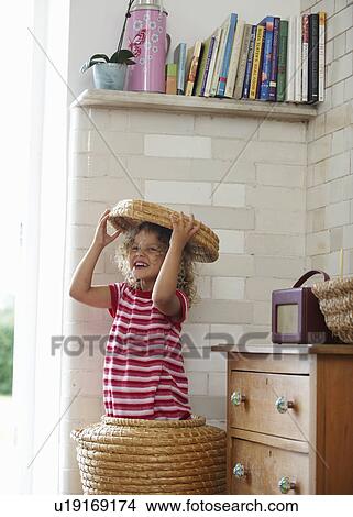 Picture - Child in laundry basket laughing. Fotosearch