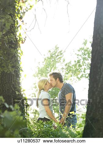 Couple kissing in woods View Large Photo Image Stock Photo - Couple kissing in woods. Fotosearch