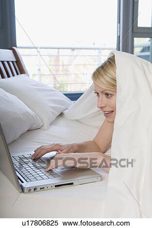 Female working on laptop in bed View Large Photo Image Stock Photography - Female working on laptop in bed. Fotosearch