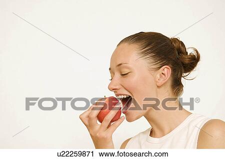 Girl eating a red apple View Large Photo Image Stock Image - Girl eating a red apple. Fotosearch