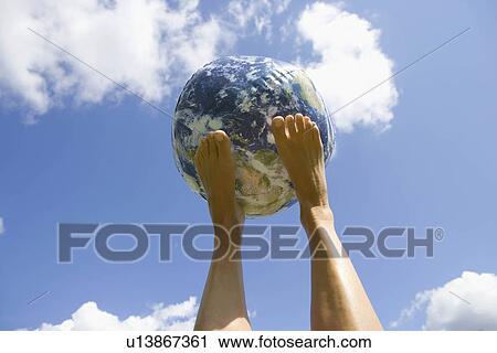 Stock Image - Globe balancing on feet. Fotosearch