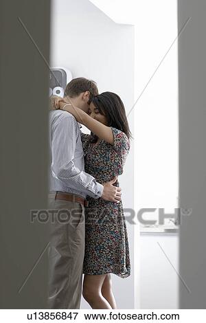 Stock Photo - Man and woman cuddling in office. Fotosearch