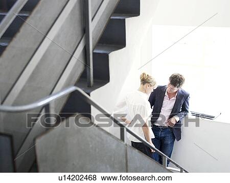 Stock Photo - Man and woman on stairs together. Fotosearch