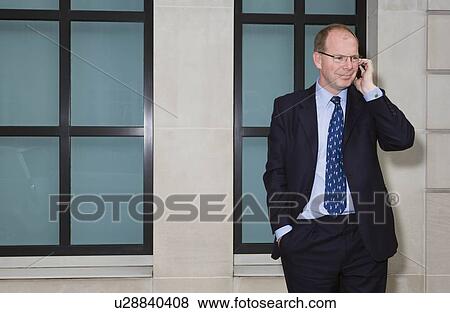 Stock Photo - Man on mobile phone smiling. Fotosearch