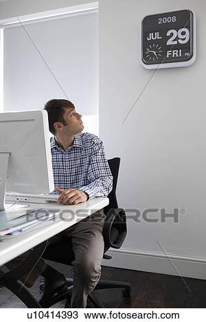 Office worker looking at clock View Large Photo Image Stock Image - Office worker looking at clock. Fotosearch