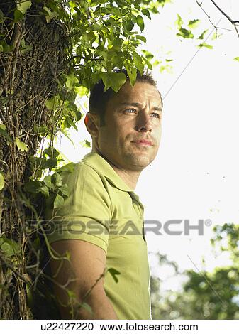 Stock Image - Portrait of young man in wood. Fotosearch