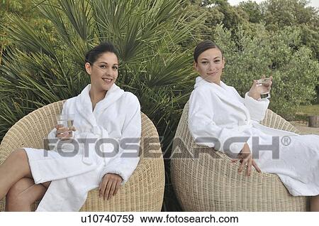 Stock Photo - Two women having a soft drink outdoors. Fotosearch