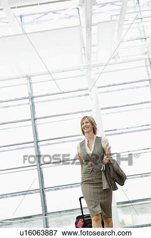 Stock Photo - Woman dragging a suitcase. Fotosearch