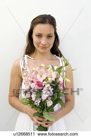 Stock Image - Woman holding flower bouquet. Fotosearch