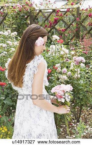 Stock Photo - Woman holding roses, side view. Fotosearch