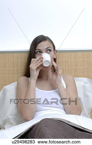 Woman in her bed with a cup View Large Photo Image Stock Image - Woman in her bed with a cup. Fotosearch