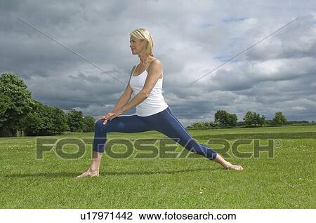 Stock Image - Woman in park stretching. Fotosearch