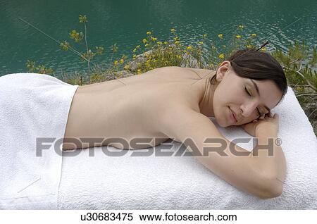 Stock Photography - Woman lying down on massage table . Fotosearch