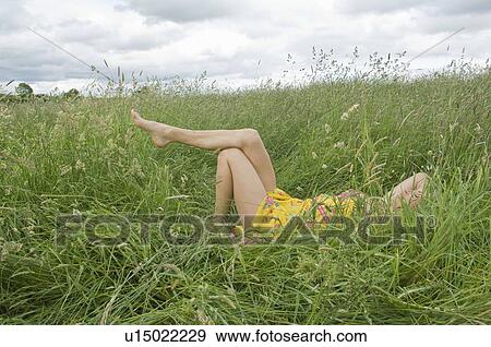 Woman lying in field showing legs View Large Photo Image Stock Photo - Woman lying in field showing legs. Fotosearch