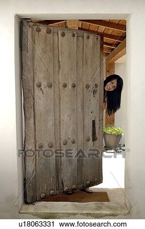 Stock Image - Woman opening front door. Fotosearch