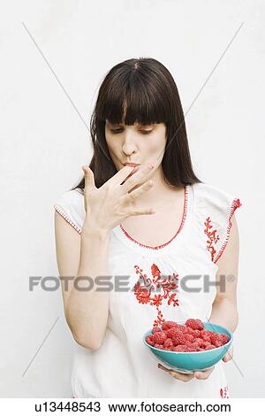 Woman tasting raspberries View Large Photo Image Stock Image - Woman tasting raspberries. Fotosearch