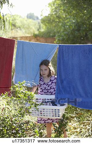 Stock Photo - Young girl carrying the washing. Fotosearch