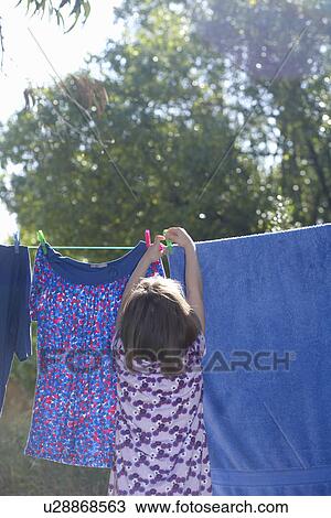 Stock Image - Young girl hanging washing. Fotosearch
