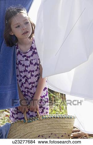 Young girl looking through washing View Large Photo Image Picture - Young girl looking through washing. Fotosearch