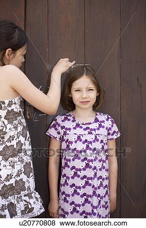 Stock Photo - Young girls measuring themselves. Fotosearch