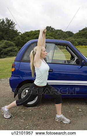 Young woman exercising by electric car View Large Photo Image Stock Photo - Young woman exercising by electric car. Fotosearch