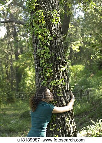 Stock Photo - Young woman hugging tree. Fotosearch