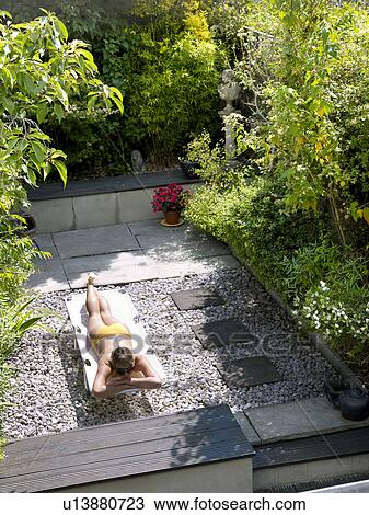 Young woman in bikini in garden View Large Photo Image Stock Image - Young woman in bikini in garden. Fotosearch