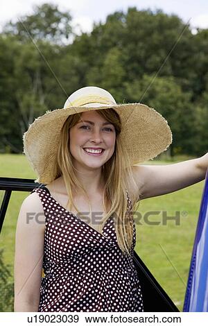 Young woman standing by electric car View Large Photo Image Stock Photo - Young woman standing by electric car. Fotosearch