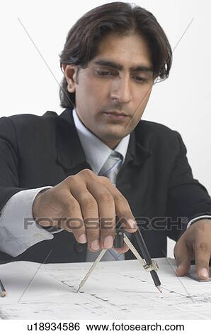 Architect using a drawing compass on a blueprint View Large Photo Image Stock Photograph - Architect using a drawing compass on a blueprint. Fotosearch