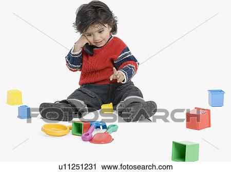 Stock Image - Boy holding a mobile phone and smiling. Fotosearch