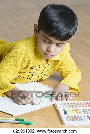 Boy lying on the hardwood floor and drawing with crayons View Large Photo Image Stock Image - Boy lying on the hardwood floor and drawing with crayons. Fotosearch